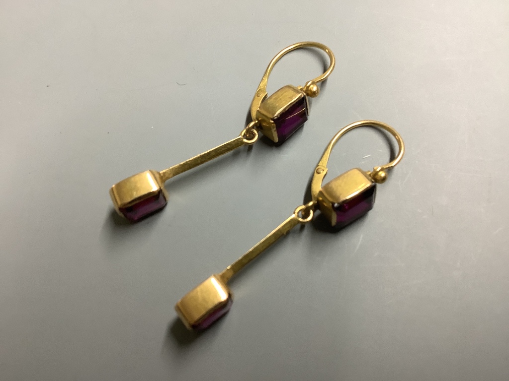 A pair of yellow metal and garnet set drop earrings